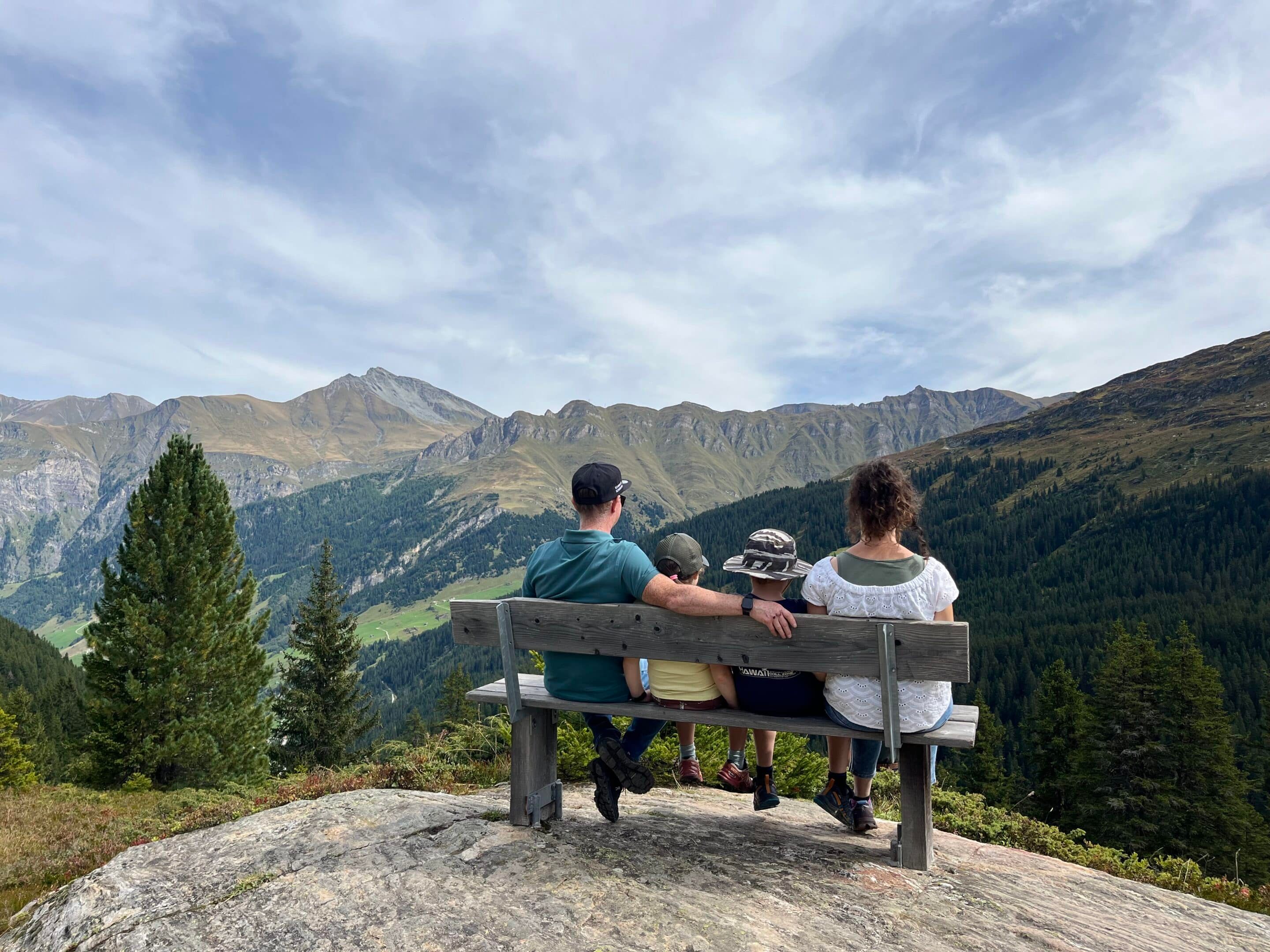Zwei Wanderer auf einer Bank mit Blick über das Valsertal