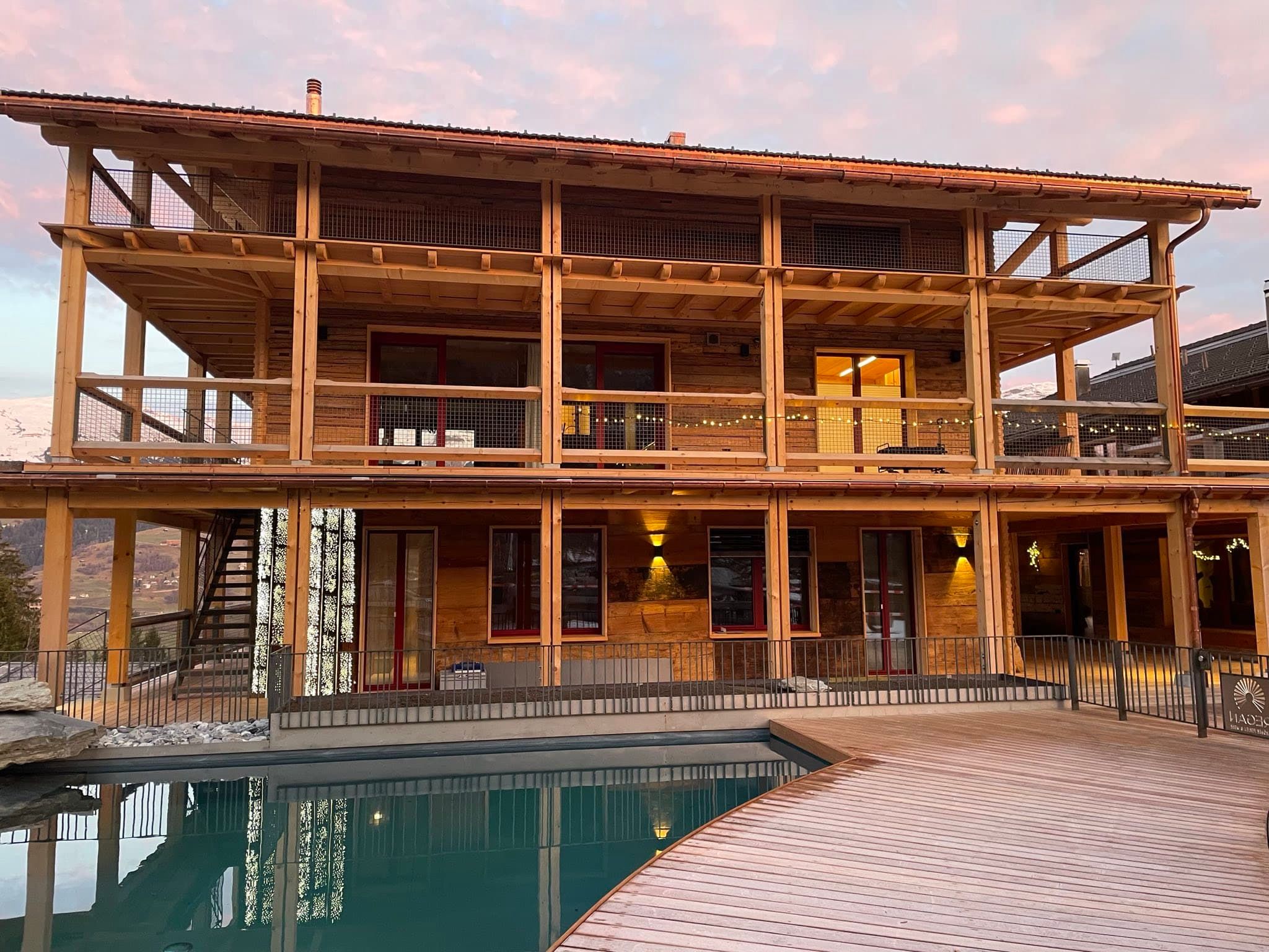 Ferienhaus REGAN mit beleuchtetem Schwimmteich am Abend – Foto 2 von 3